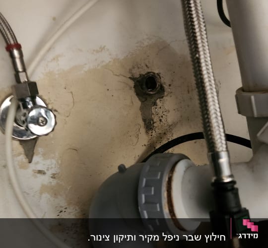 צינורות מתכת ופלסטיק מתחת לכיור עם חיבורים